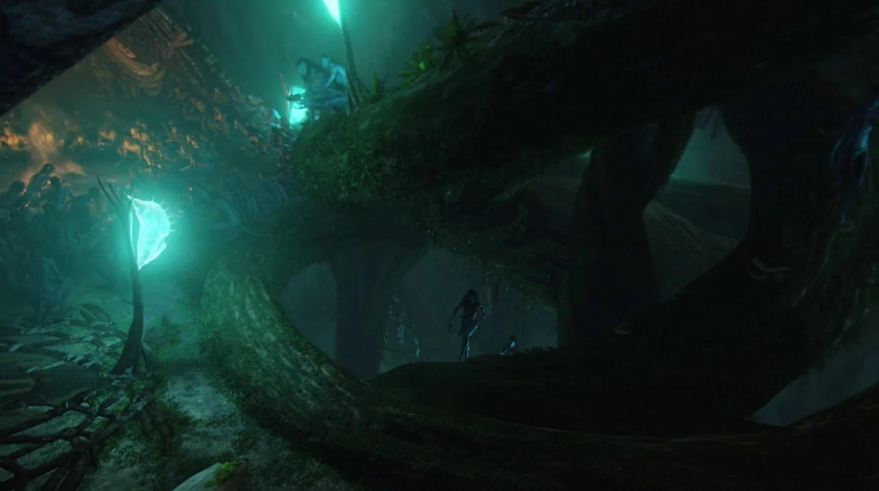 Avatar (2009) movie still: wide — A gargantuan, hollow alien tree trunk features bioluminescent plants casting a green hue. Many slender,…