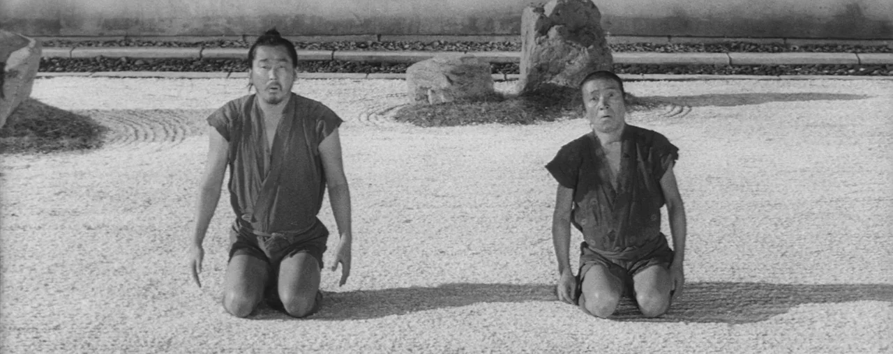 The Hidden Fortress (1958) movie still: fullbody — A raked white gravel zen garden features large decorative rocks and a stone wall. Two men in…
