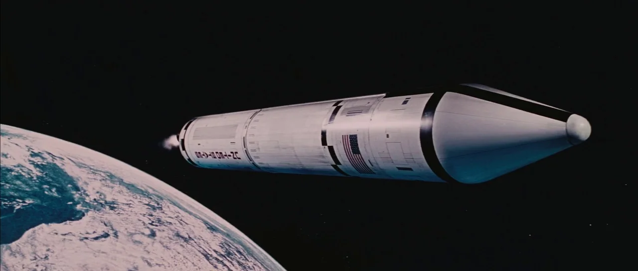 Diamonds Are Forever (1971) movie still: wide — A metallic American rocket floats in the vast darkness of space above Earth. The curved planet with…
