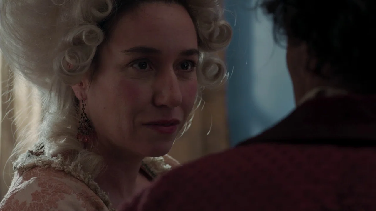 Zama (2017) movie still: closeup — A dimly lit indoor space with period architecture visible in the blurred background. A woman wearing an…