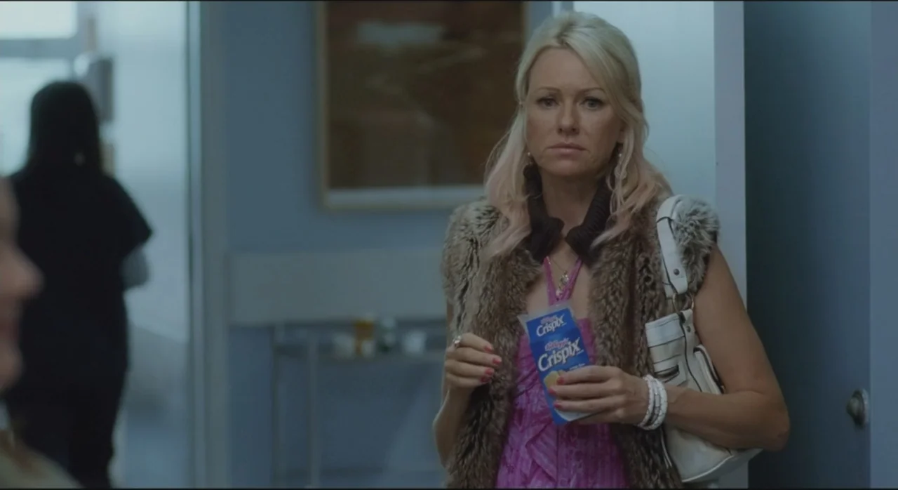 St. Vincent (2014) movie still: medium — A light blue hospital corridor features an out-of-focus figure in the background. A blonde woman in a fur…