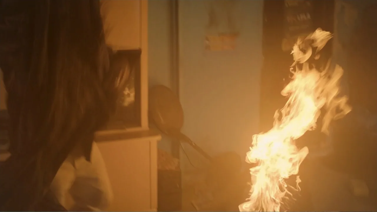 Unknown #1 movie still: medium — An interior space is filled with bright flickering light from an intense fire.