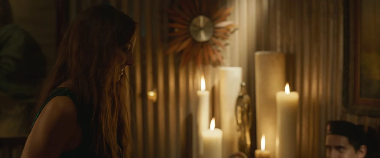Crazy for Change (2020) movie still: medium — A dimly lit interior room features a corrugated metal wall and a decorative sunburst clock. A woman in…