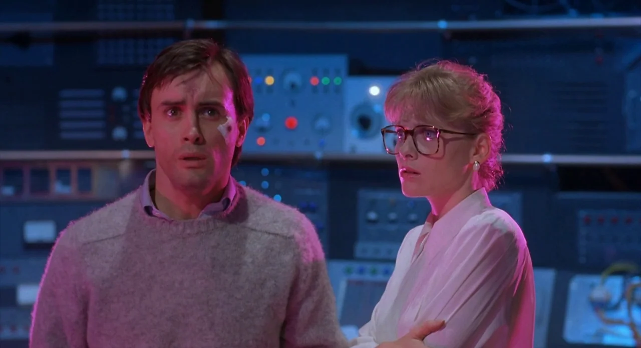 From Beyond (1986) movie still: medium — An interior space filled with electronic hardware racks featuring numerous colorful status indicator…
