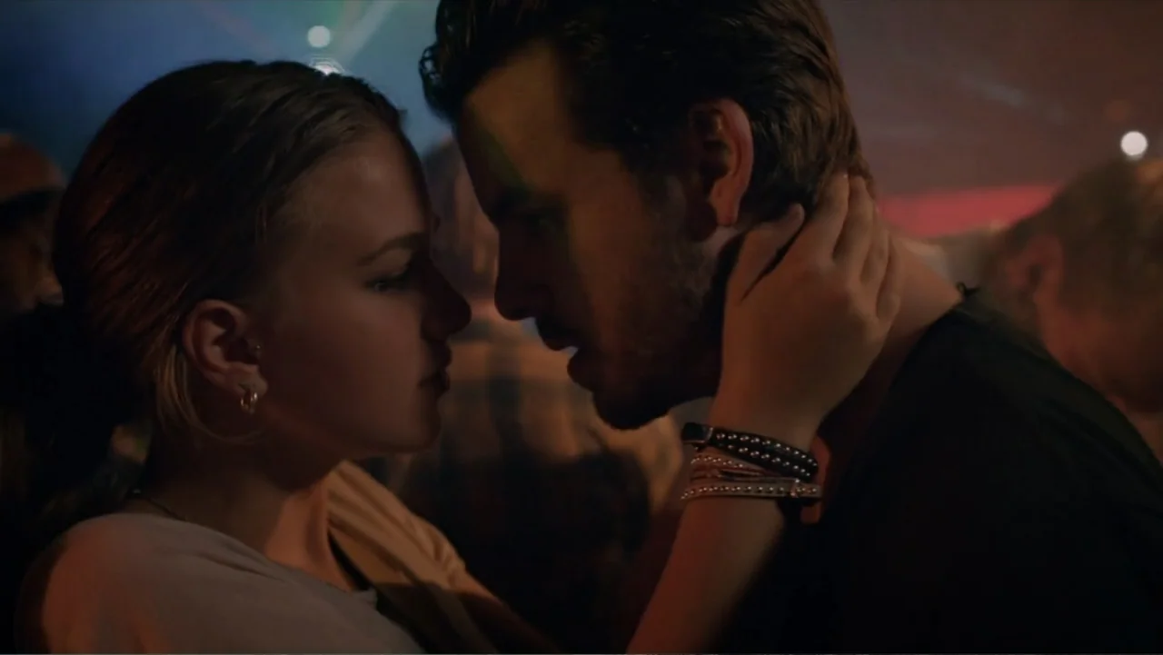 Copenhagen (2002) movie still: closeup — A dimly lit, crowded dance floor features two young people standing face to face. The couple holds each…