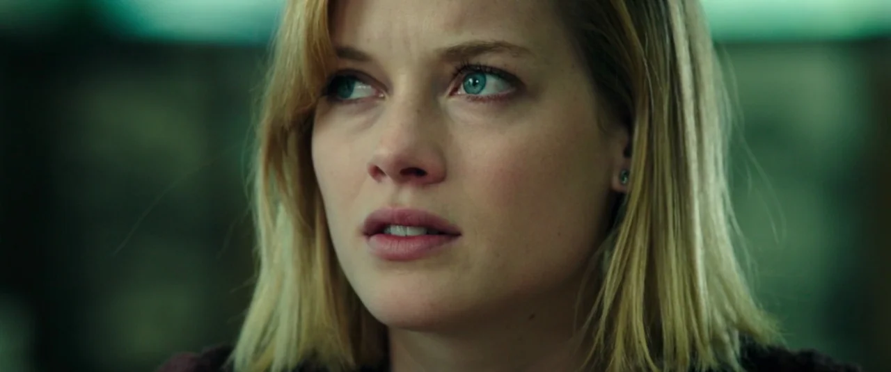 Don’t Breathe (2016) movie still: closeup — A close-up shot of a young woman inside an indoor space. The background is out of focus and appears…