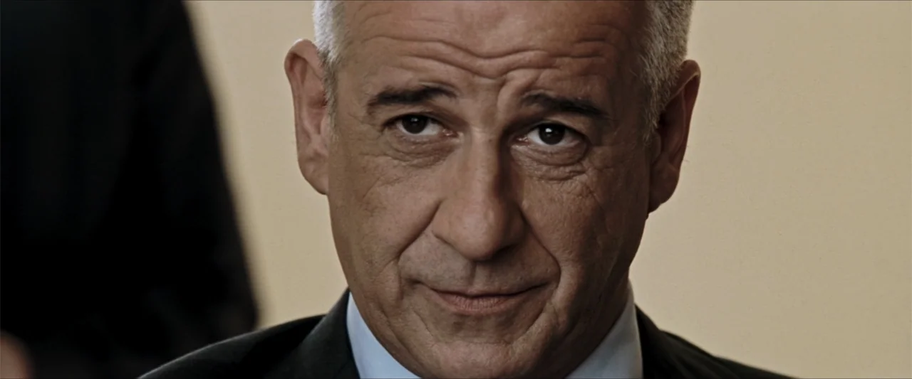 GOMORRAH (2023) movie still: closeup — A professional interior space features a man centered in the shot. The man faces the camera while wearing a…