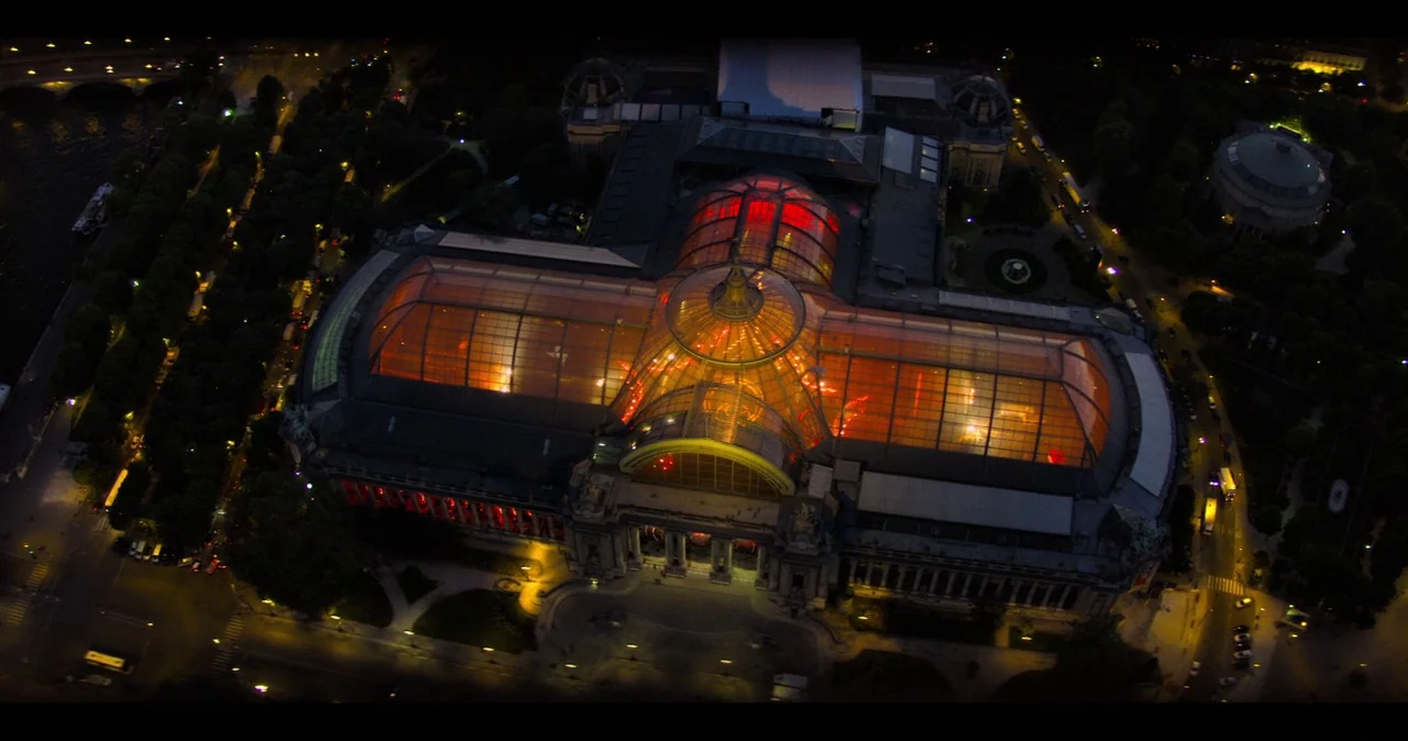 Mission: Impossible – Fallout (2018) movie still: establishing — An aerial view captures the glass-roofed Grand Palais at night in Paris. The…