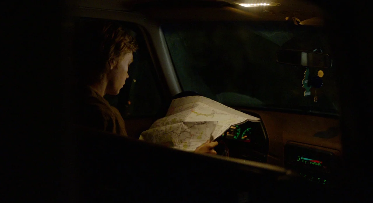 Lean on Pete (2017) movie still: medium — A dark, cramped car interior lit by dim dashboard illumination at night. A young man sits in the passenger…