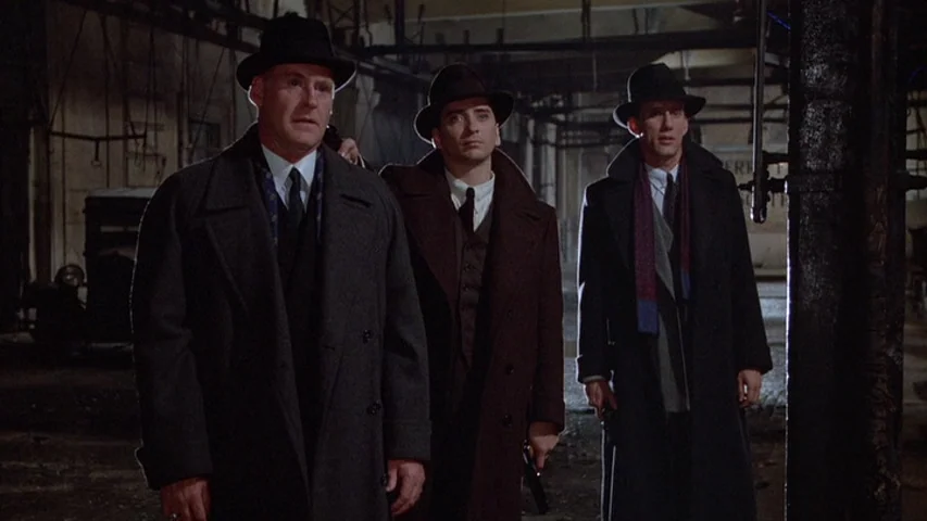 Once Upon A Time In America (1984) movie still: medium — A dimly lit industrial interior featuring steel beams and shadows in the background. Three…
