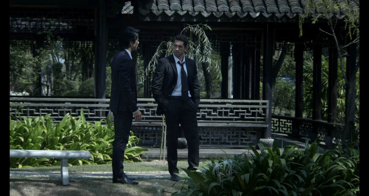 Ninja: Shadow of a Tear (2013) movie still: fullbody — A traditional wooden pavilion with dark tiling stands within a lush green garden. Two men in…