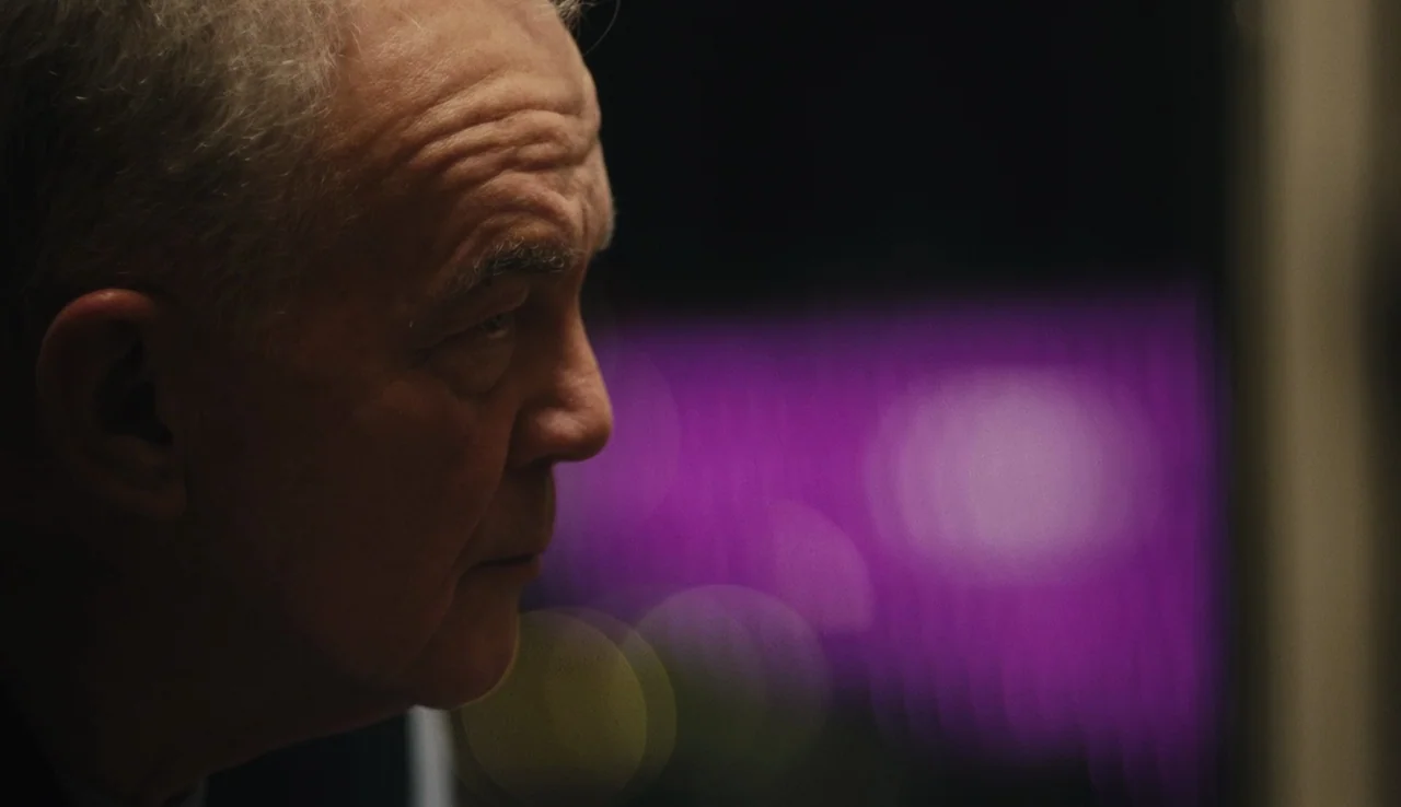 Land Ho! (2014) movie still: closeup — A dimly lit room provides a dark background for an older man in profile. The man's face is partially…
