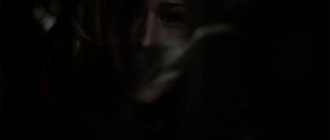 Joy Ride (2001) movie still: closeup — A very dark, indistinct interior setting with a person's face emerging from deep shadow. The person faces…
