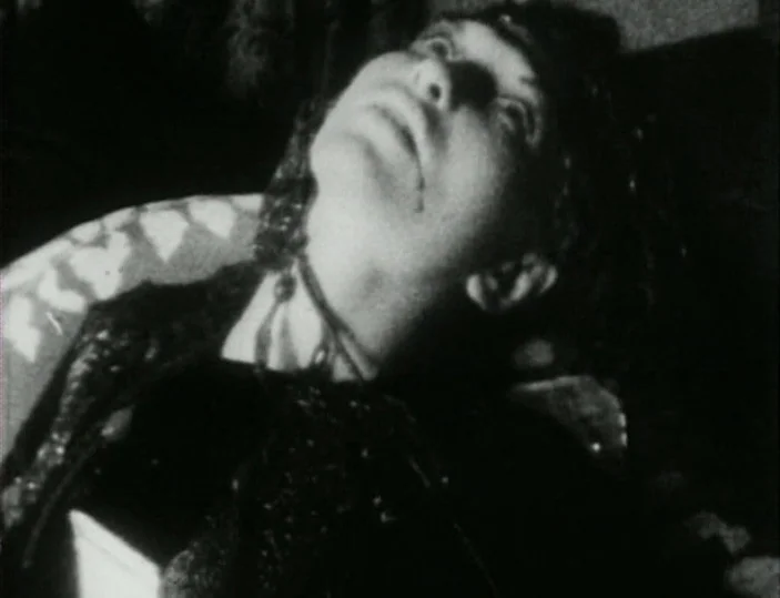 Meshes of the Afternoon (1943) movie still: closeup — A dark indoor space is partially lit by a single harsh light source. A woman with dark hair…