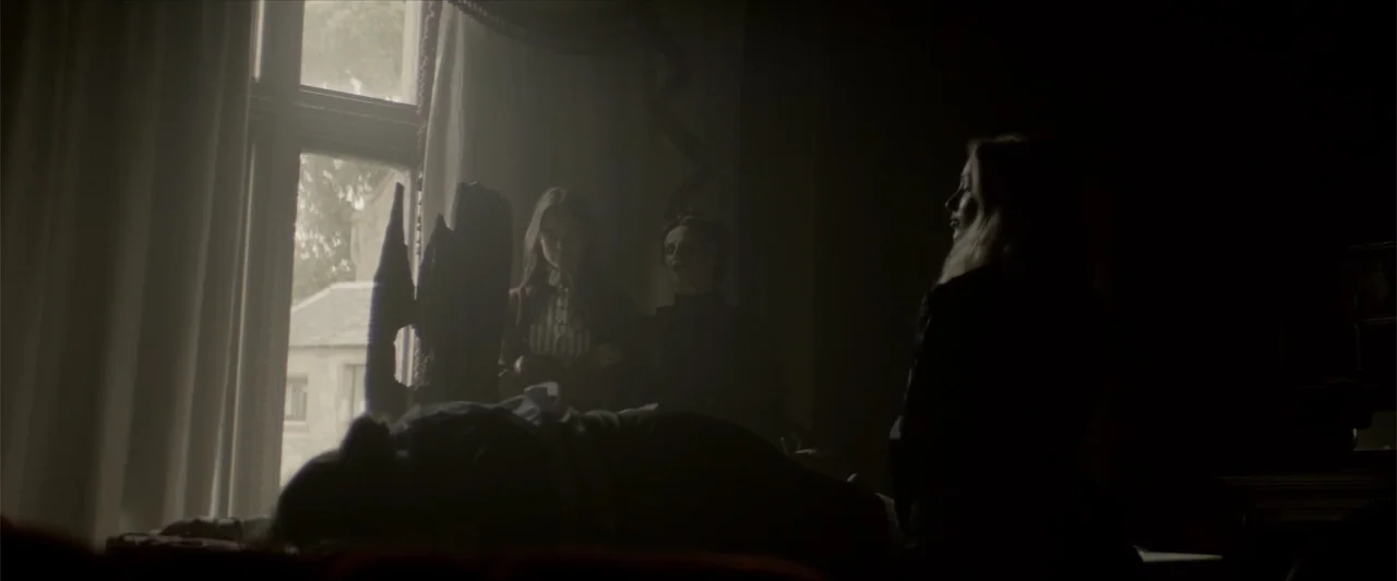 Cinderella's Curse (2024) movie still: medium — A dimly lit room features a large window with white curtains and shadowy figures. Three women stand…