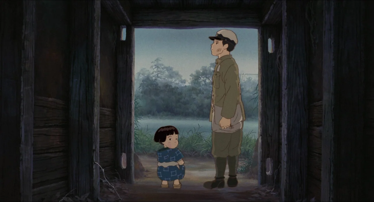 Grave of the Fireflies (1988) movie still: fullbody — A dark wooden structure frames an outdoor view of green grass and trees. A young boy in a…