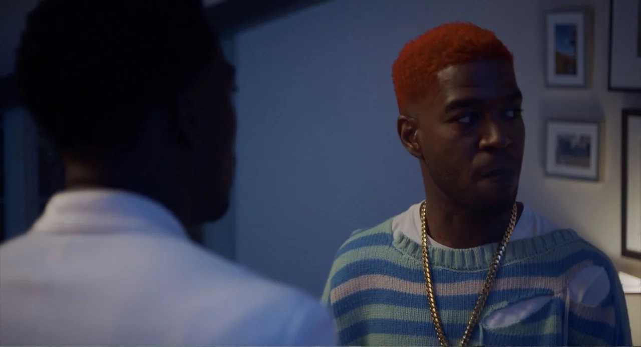 House Party (1990) movie still: medium — An interior space features a man with bright orange hair and a striped sweater. He turns his head slightly…
