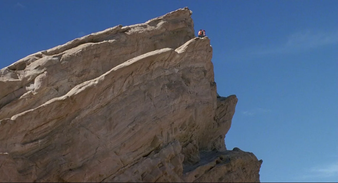 Bill and Ted’s Bogus Journey (1991) movie still: wide — A massive, light-colored sedimentary rock formation stands against a clear, deep blue sky.…