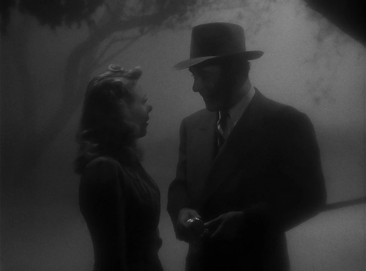 The Wolf Man (1941) movie still: medium — A man and a woman stand together in a dark, heavily fog-covered outdoor space. They are positioned face to…