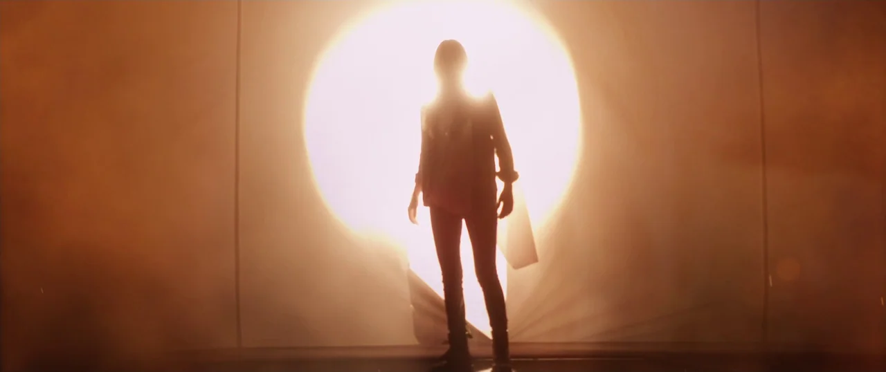 Final Girls (2015) movie still: fullbody — A person stands centered before a bright circular light source on a large stage. The silhouette of the…