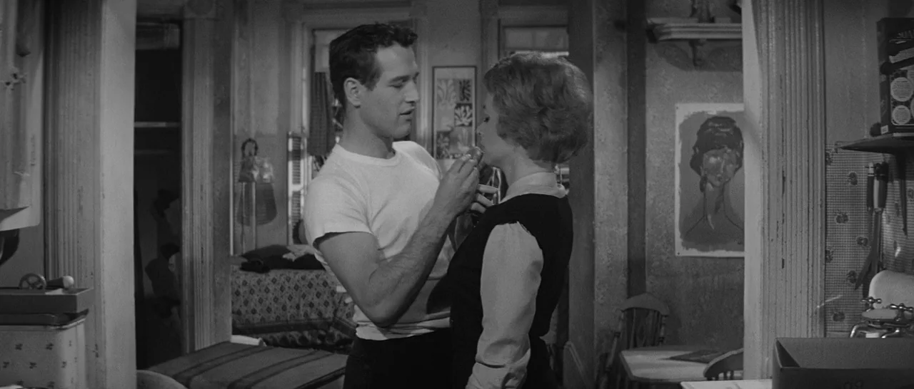 The Hustler (1961) movie still: medium — A modest, lived-in apartment features worn wallpaper and simple furniture pieces in the background. A man…