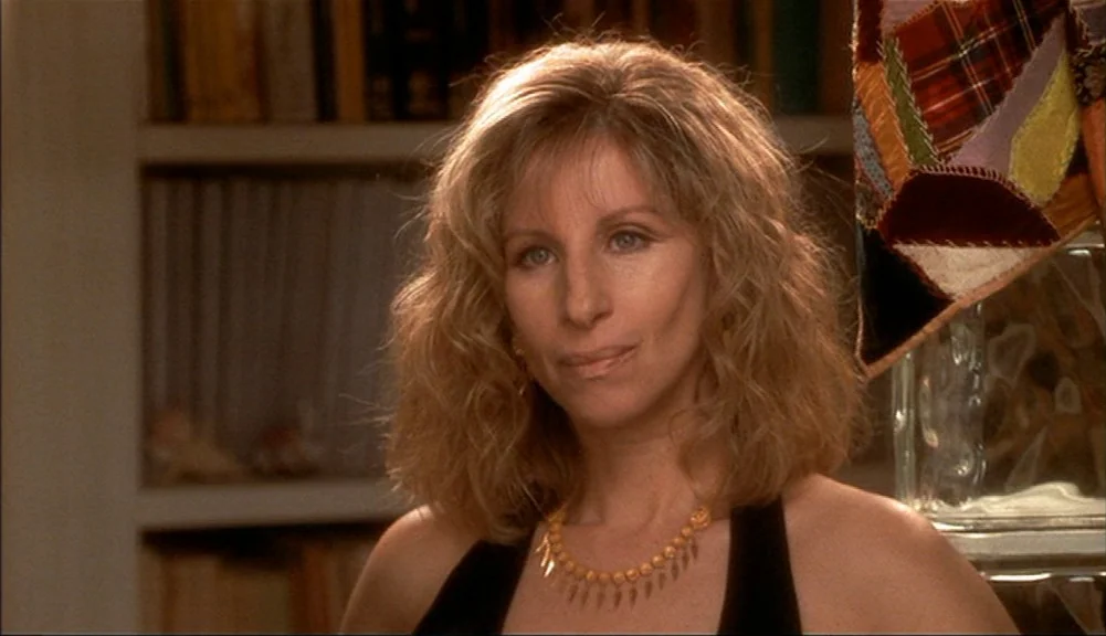 The Mirror Has Two Faces (1996) movie still: closeup — A residential library background features shelves filled with books and a glass block…