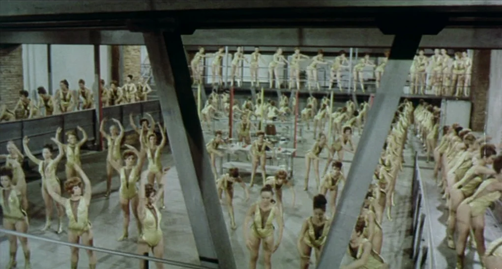 Dr. Goldfoot and the Girl Bombs (1966) movie still: wide — A large industrial studio space features numerous dancers performing synchronized…
