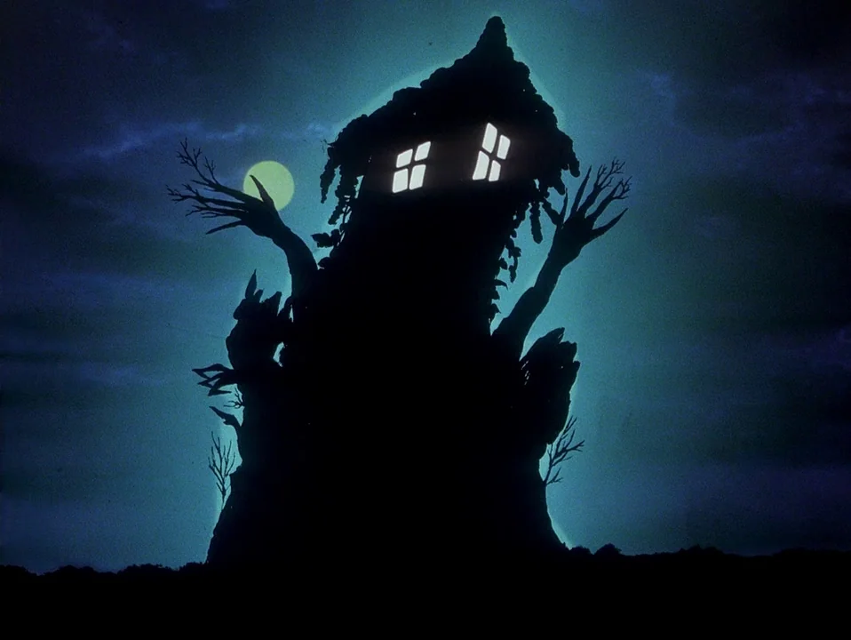 House (Hausu) (1977) movie still: wide — A dark tree structure stands against a night sky with a pale moon. Two glowing square windows are visible…