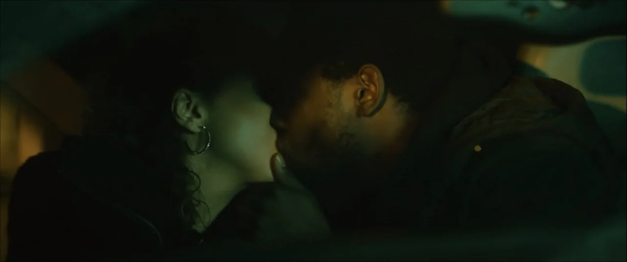 I'll Take Your Dead (2018) movie still: closeup — The interior of a vehicle at night is illuminated by muted green tones. A man and a woman lean…