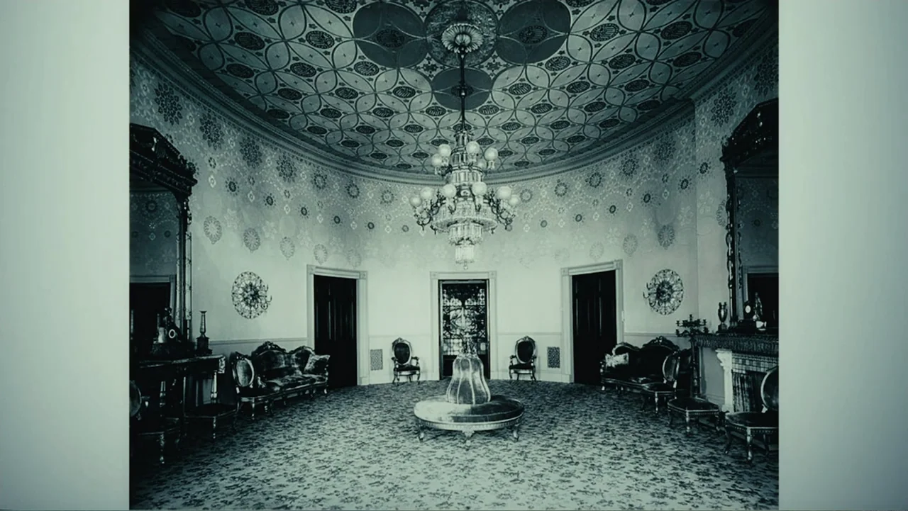 Demon in the White House (2021) movie still: establishing — A circular room features an ornate patterned ceiling and intricate wallpaper patterns. A…