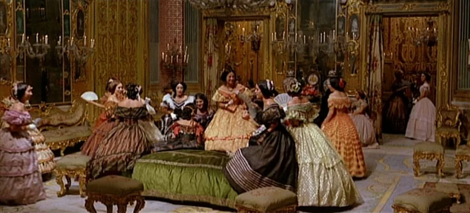 The Leopard (1963) movie still: wide — A lavish 19th-century salon features gilded wood paneling, ornate wall mirrors, and velvet furniture. A group…