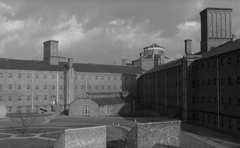 The Criminal (1960) movie still: establishing — A sprawling 19th-century brick prison complex features symmetrical wings and tall ventilation…