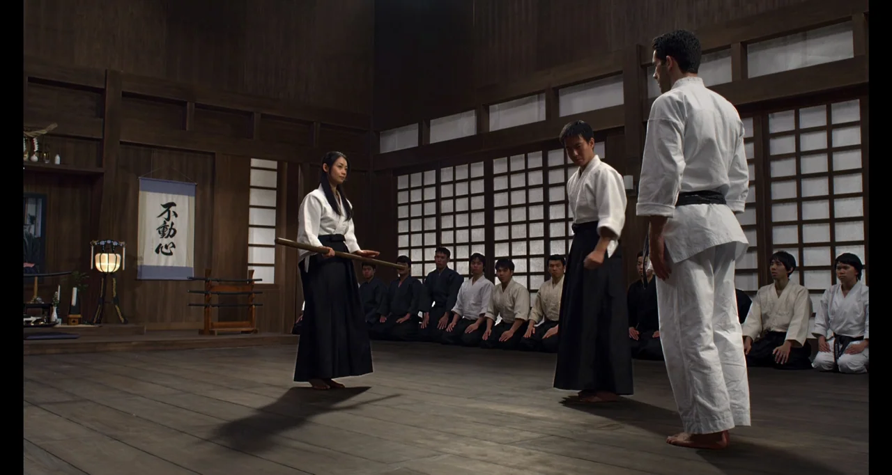Ninja: Shadow of a Tear (2013) movie still: fullbody — A spacious wooden-floored dojo features traditional paper partitions and a wall hanging…