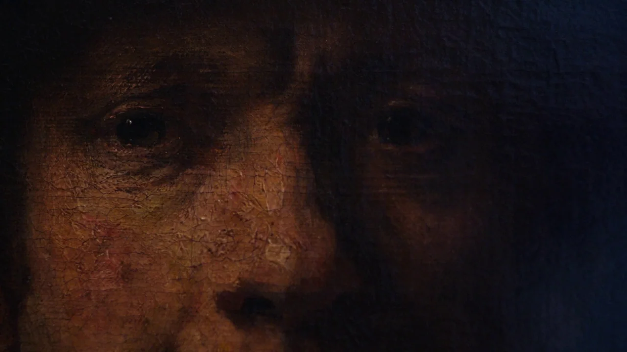 Museum Hours (2012) movie still: closeup — A close-up view of a detailed oil painting depicting an elderly man's weathered face. The paint surface…