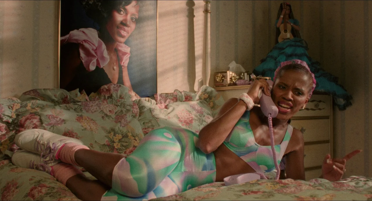 Mississippi Masala (1991) movie still: medium — A teenage bedroom decorated with floral bedding and a portrait hung on the wall. A woman lies across…