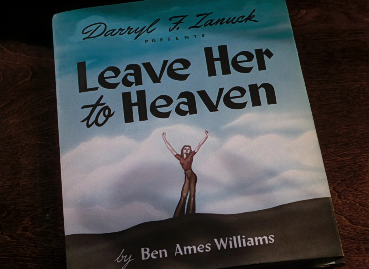 Leave Her To Heaven (1945) movie still: closeup — A close-up view of a book titled Leave Her to Heaven rests on a table. The cover features a…