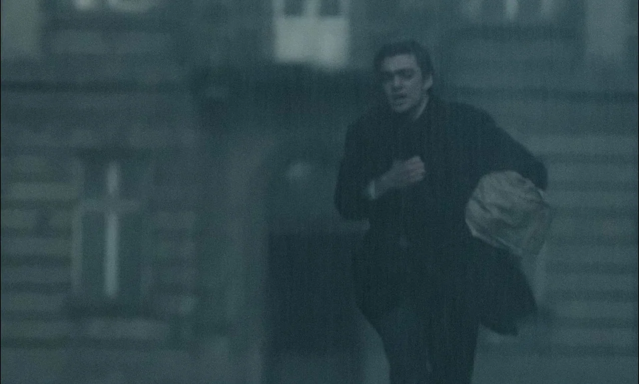 The Third Part of the Night (1971) movie still: medium — A man sprints through a dense, fog-covered urban space at night. He holds a paper bundle…