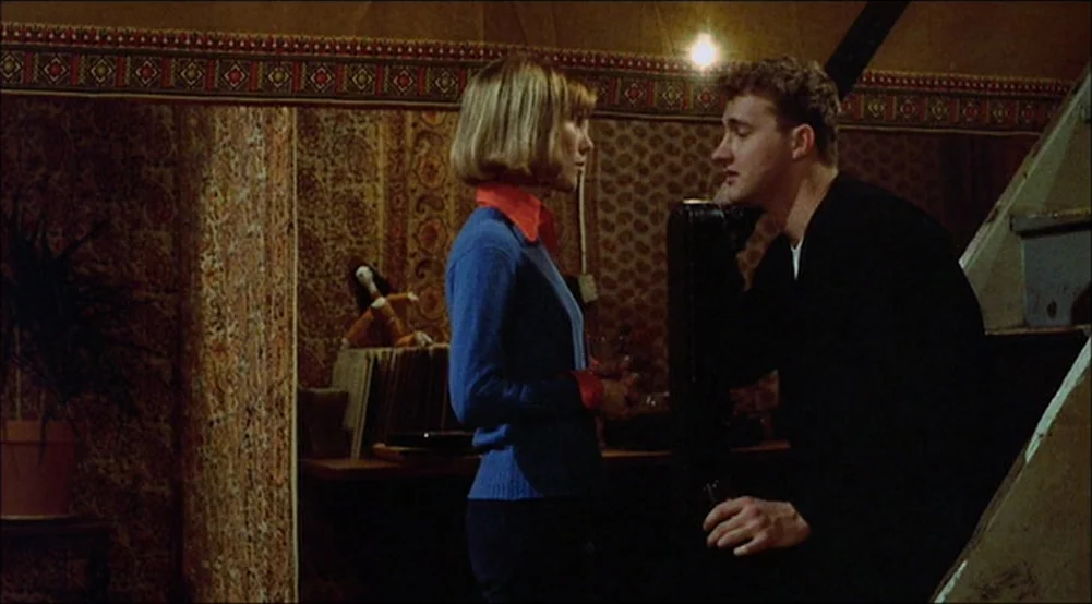The Last Detail (1973) movie still: medium — An interior space features patterned wallpaper and a wooden staircase in the corner. A woman in a blue…