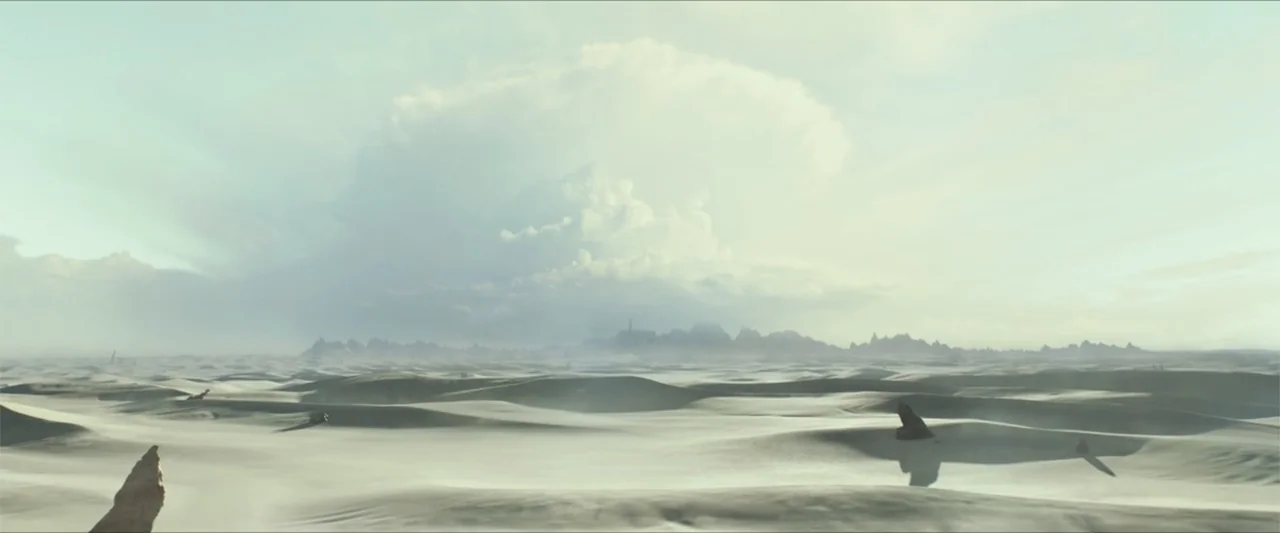 Monster Hunter (2020) movie still: establishing — A vast, flat desert landscape stretches toward a distant, low-lying mountain range. A single…