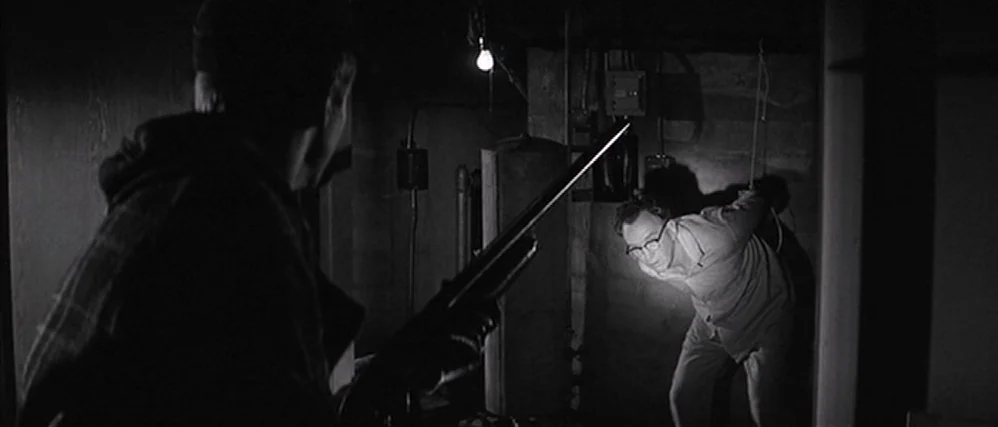 In Cold Blood (1967) movie still: medium — A dark, unfinished concrete basement with exposed wiring and pipes. A man with a shotgun threatens…