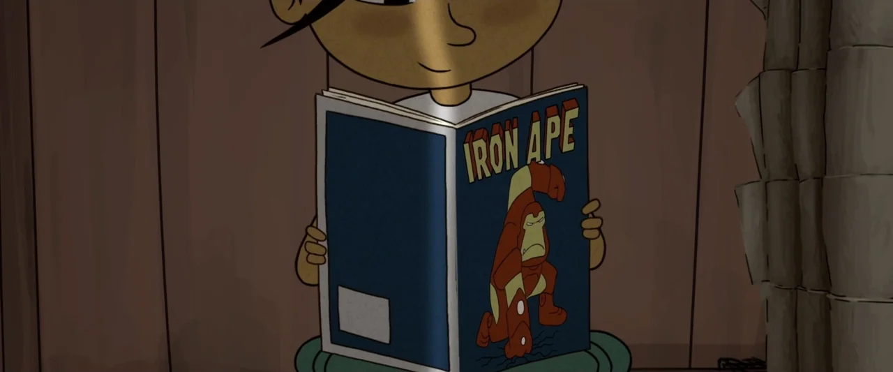 The Ape Star (2021) movie still: medium — A cartoon child stands indoors against simple brown walls. The character holds an open comic book titled…
