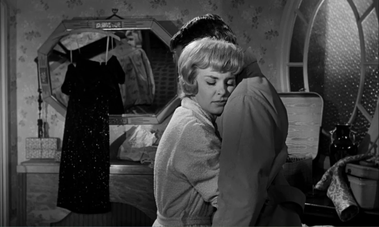 Paris Blues (1961) movie still: medium — A 1960s bedroom with floral wallpaper, a large wall mirror, and vanity furniture. A blonde woman in a robe…