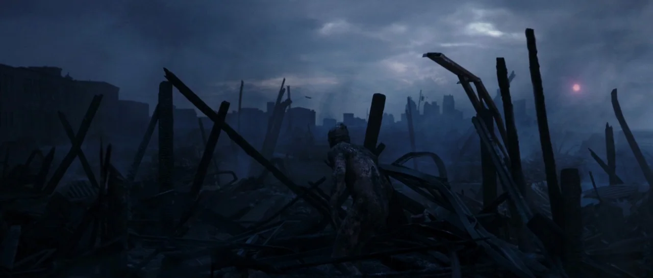 Deadpool (2016) movie still: wide — A desolate, ruined city landscape features charred wooden beams and piles of structural debris. A singular…