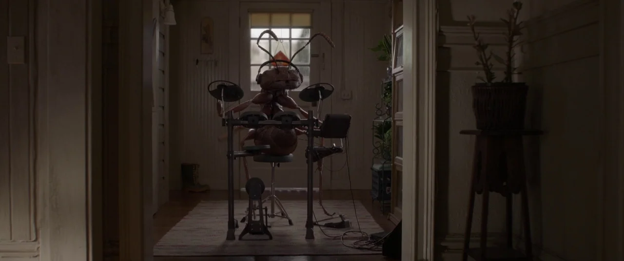 Ant-Man and the Wasp (2018) movie still: medium — A dimly lit residential house interior with wood-paneled walls and a rug. An anthropomorphic…