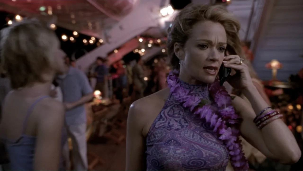 What Women Want (2000) movie still: medium — A crowded cruise ship deck at night features numerous small hanging lights. A blonde woman in a…