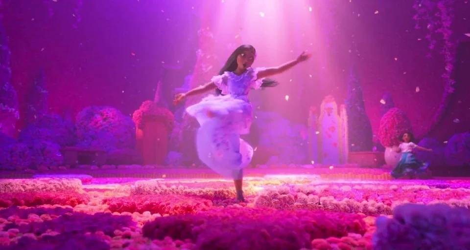 Encanto (2021) movie still: fullbody — A field filled with dense clusters of pink and purple roses under a light. A woman in a flowing dress dances…