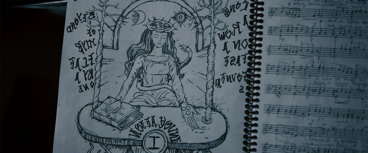 Nocturne (2020) movie still: closeup — A close-up view of an open spiral-bound notebook featuring a detailed ink illustration. The left page…