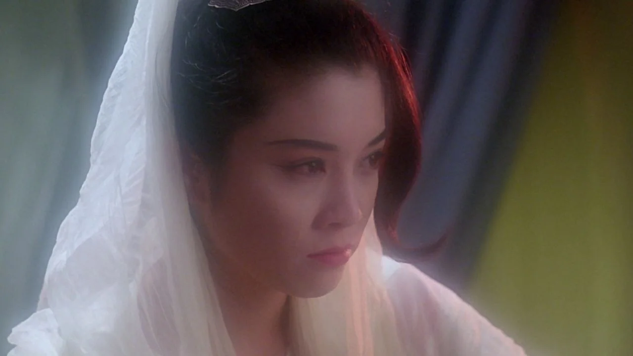 The Bride with White Hair II (1993) movie still: closeup — A close-up shot showing a woman with a translucent white veil in a room. She looks…