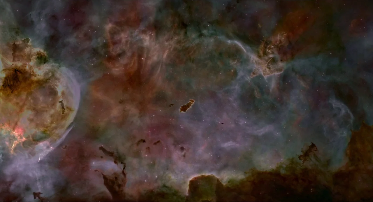 Voyage of Time (2016) movie still: establishing — Vast interstellar gas clouds span the frame with swirling textures of dust and light. Dark regions…