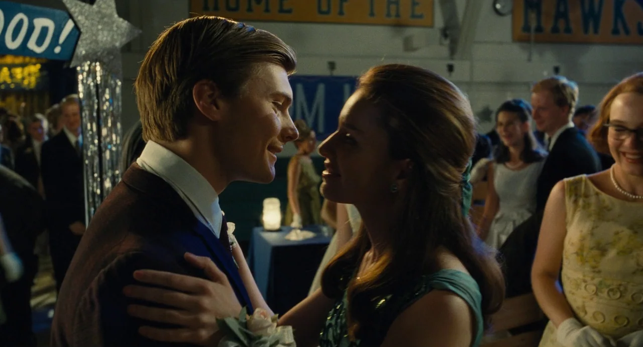 The Fabelmans (2022) movie still: medium — A gymnasium interior features school banners and metallic decorations typical of a school dance. A young…
